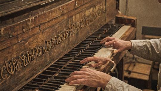 Piano repair technician working on piano action